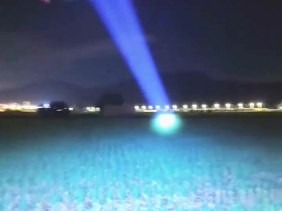 Headlamp beam reaching far across a dark field