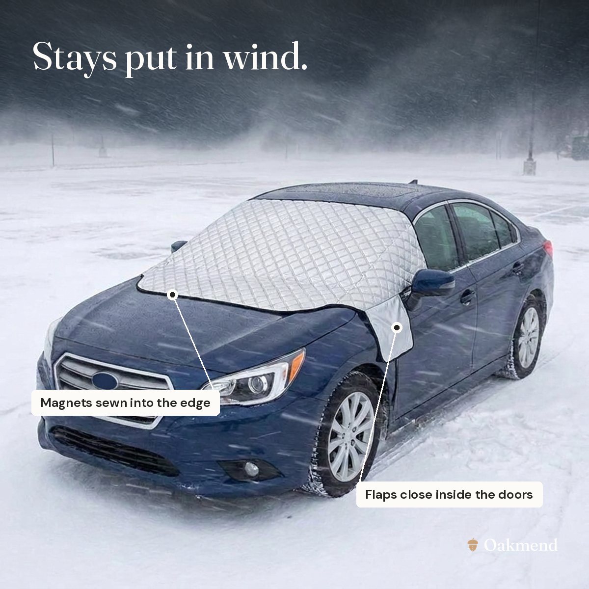 Silver windshield cover staying in place on a car in a snowstorm