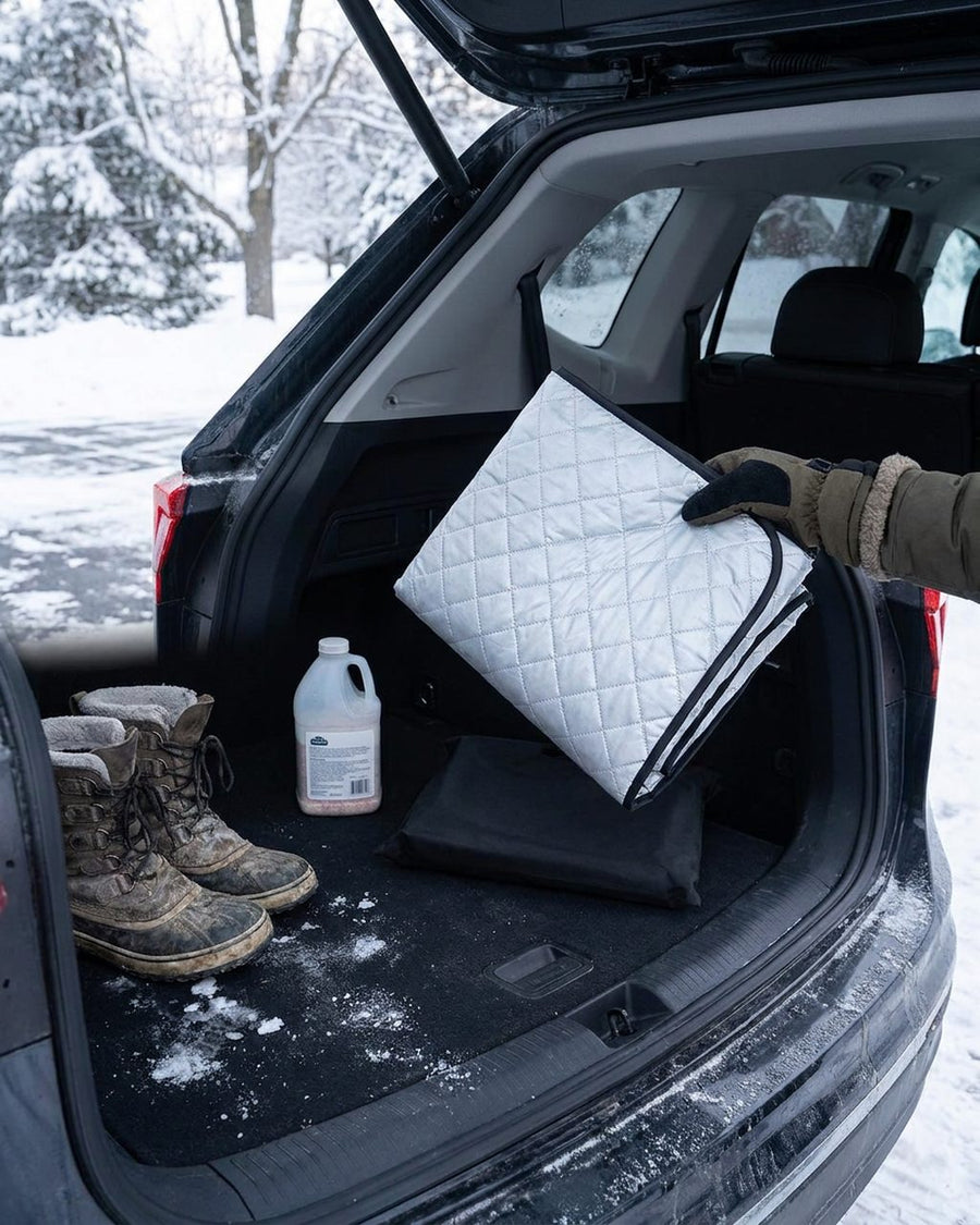 Folded windshield cover stored in an SUV trunk